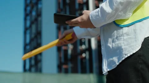 A professional builder in a KN 95 mask and hard hat at a construction site is ta Vidéo 249262936