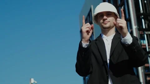 A professional builder in a KN 95 mask and hard hat at a construction site is ta Vidéo 249263170