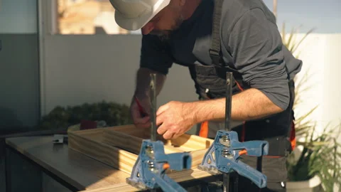 Professional builder in safety helmet constructing wooden shelving unit on .. Vídeos de archivo 336026614