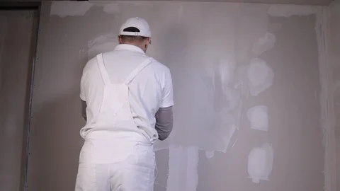 Professional builder with spatula Applies Plaster To The Wall Stock Footage 101383031