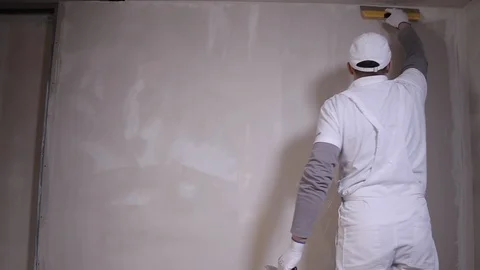 Professional Builder With Spatula Applies Plaster To The Wall Stock Footage 101383047