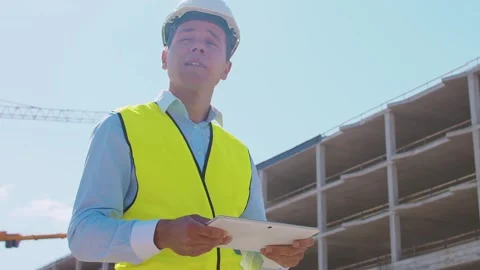 Professional builder standing in front of construction site. Foreman in hardhat Stock Footage 308479371