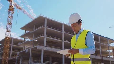 Professional builder standing in front of construction site. Foreman in hardhat Stock Photos