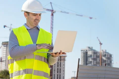 Professional builder standing with notebook in front of the construction site Stock Photos