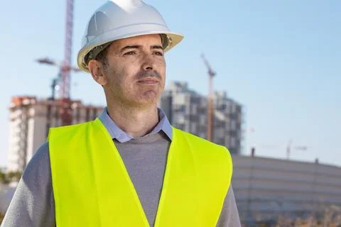 Professional builder standing with notebook in front of the construction site Stock Photos