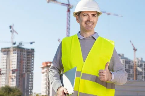 Professional builder standing with notebook in front of the construction site Stock Photos
