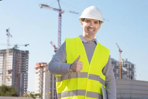 Professional builder standing with notebook in front of the construction site Stock Photos