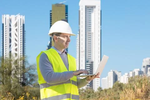 Professional builder standing with notebook in front of the construction site Stock Photos