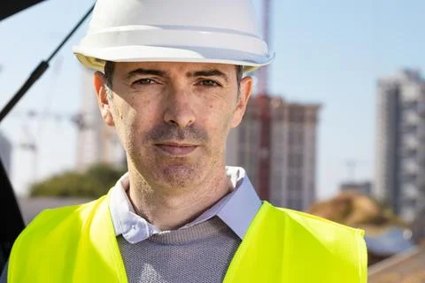 Professional builder standing with notebook in front of the construction site Stock Photos