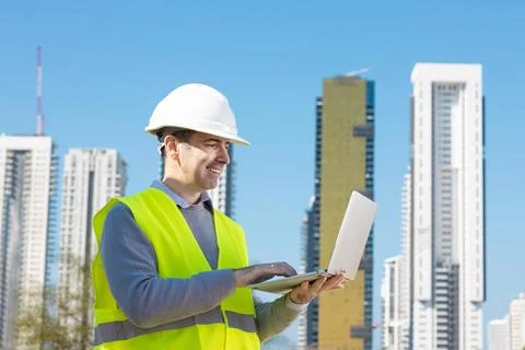 Professional builder standing with notebook in front of the construction site Stock Photos