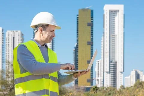 Professional builder standing with notebook in front of the construction site Stock Photos