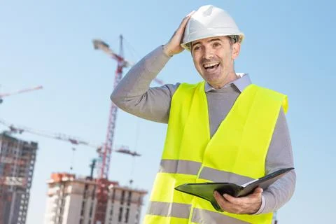 Professional builder standing with notebook in front of the construction site Stock Photos