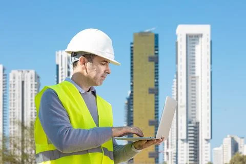 Professional builder standing with notebook in front of the construction site Stock Photos