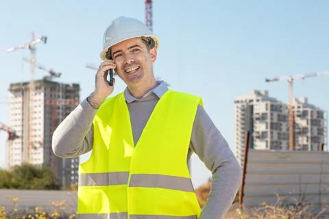 Professional builder standing with notebook in front of the construction site Foto stock