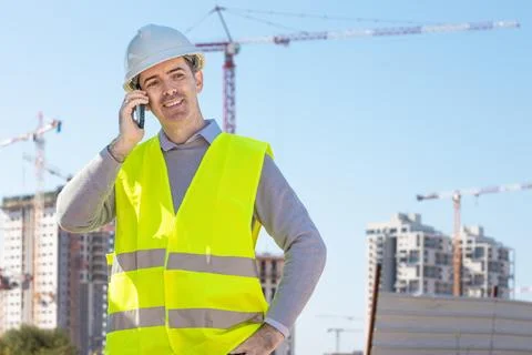 Professional builder standing with notebook in front of the construction site Stock Photos