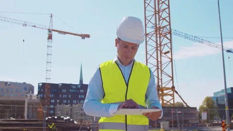 Professional builder standing with tablet computer in front of construction site Stock Footage 144429430
