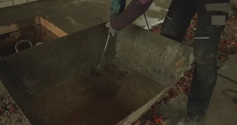 Professional builder using an electric mixer to prepare a fresh cement solution Vídeos de archivo 338244374