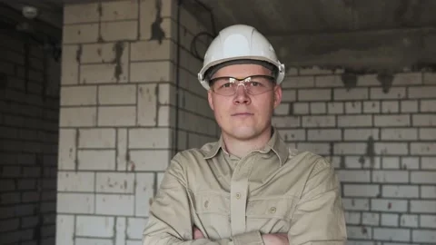 A professional builder in a white helmet and glasses looks at the camera Stock Footage 238506072