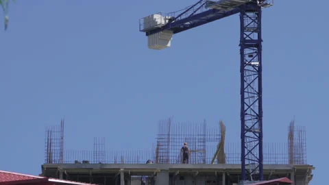 Professional builders in overalls are erecting a metal frame for the Stock Footage 142671553