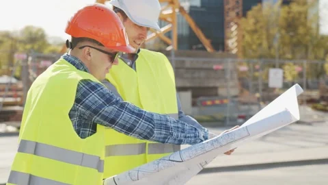 Professional builders standing in front of construction site. Office building Stock Footage 138514006