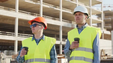 Professional builders standing in front of construction site. Office building Stock Footage 138520389
