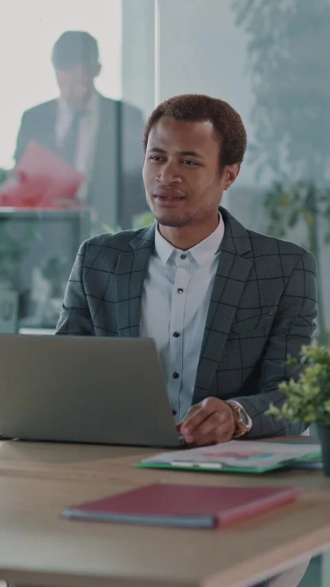 A Professional Businessman Engaged in Focused Work on Laptop Within a Modern Stock Footage 313793588
