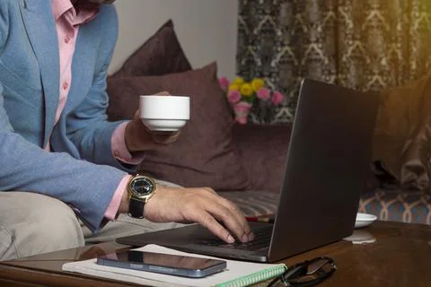 Professional businessman working from while while drinking his coffee Stock Photos