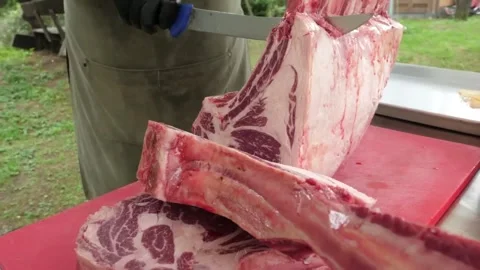 Professional Butcher Cutting Fresh Raw Tomahawk Ribeye Steak for Barbecue Stock Footage 338212911