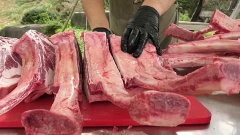 Professional Butcher Cutting Raw Marbled Beef Tomahawk Steaks for Barbecue Stock Footage 338214224
