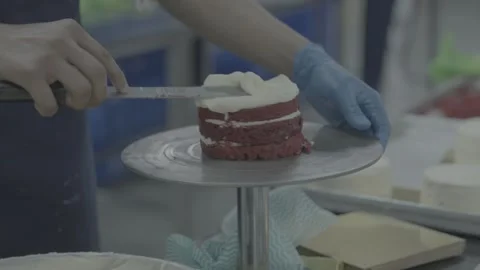 Professional cake icing process on a turntable with a spatula in a bakery Stock-Footage 327358391
