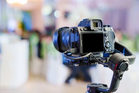 A professional camera on the blurred background of a banquet hall. Stock Photos