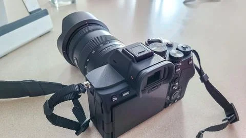 Professional camera with large lens resting on a table, showcasing advanced Stock Photos