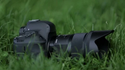 Professional camera with the lens lies on the grass Stock Footage 70681398