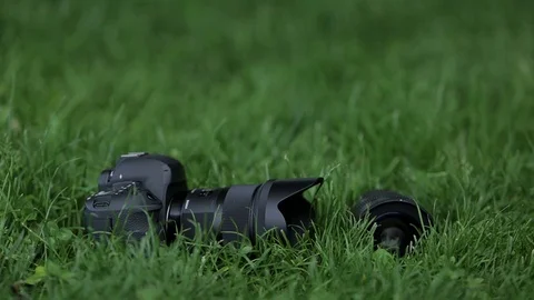 Professional camera with the lens lies on the grass Stock Footage 70681409