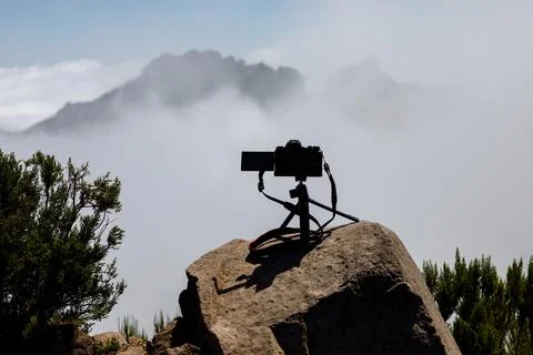 A professional camera with a rotating screen on a tripod shooting the movemen Stock Photos