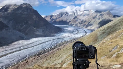 Professional camera on a tripod filming glacier in Swiss alps, Aletsch glacier Video stock 319917968
