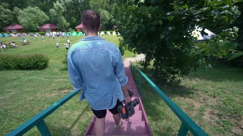 Professional cameraman descends down the stairs to the set. Director of photogra 스톡 동영상 123712774