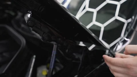 Professional car detailing worker applying paint protection film Видео 326427654