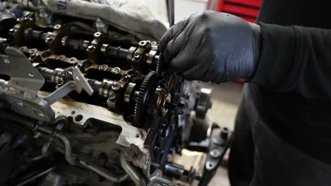 Professional car mechanic disassembling engine from a modern vehicle repair shop 库存影片 231014233