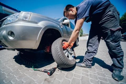 Professional car mechanic replace tire on wheel. Foto stock