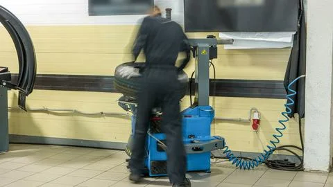 Professional car mechanic replace tire on wheel in auto repair service time.. Foto stock