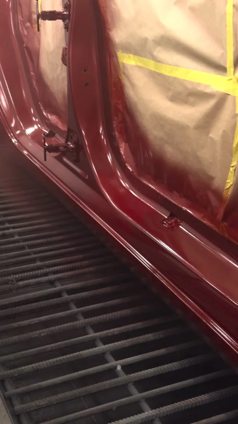 Professional car painter applying new red paint with spray gun in booth Stock Footage 339326935