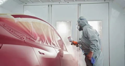 Professional Car Painter Applying Red Paint in a Car Chamber Stock Footage 276605746