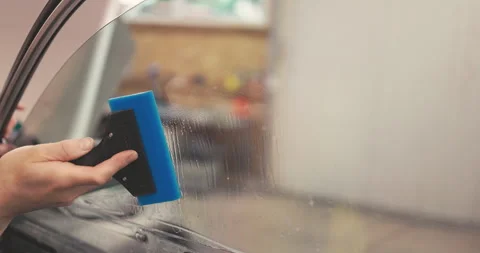 Professional Car tinting services for windows Worker specialist apply tint foil Stock Footage 338432800