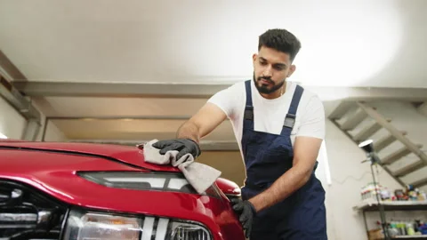 Professional car wash worker holding the gray microfiber and polishing the car Stock Footage 234019681