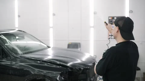 Professional car wrapper applying vinyl wrap on vehicle Stock Footage 314656382