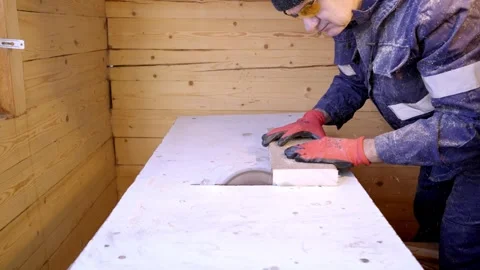 A professional carpenter cuts wood with a circular saw. Stockbeeldmateriaal 264018969