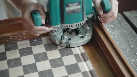 Professional carpenter using grinding machine for carving holes on the sides of Stockbeeldmateriaal 221982038