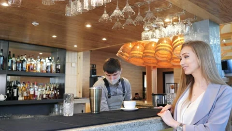 A professional Caucasian bartender in a mask, creating a cocktail in front of a Stock Footage 172410076