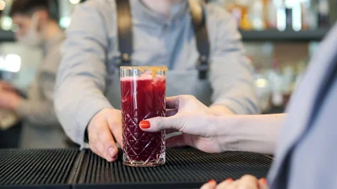 A professional Caucasian bartender in a mask, creating a cocktail in front of a Stock Footage 172410481